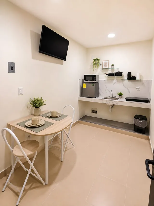 Cocina-comedor de LUMA con mesa para dos, fregadero y repisas