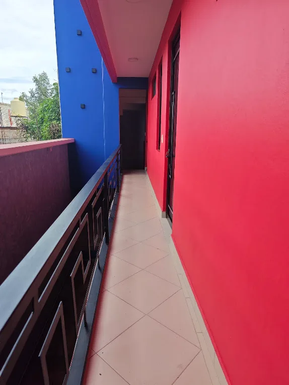 Pasillo del segundo piso de LUMA con barandal y paredes rojas y azules